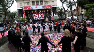 Participantes de mãos dadas em volta de corações espalhados pela praça. #pratodosverem