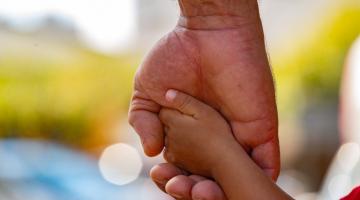 mão masculina segura a mão de uma criança. #paratodosverem