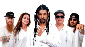 grupo musical com cinco pessoas todas vestidas de branco. #paratodosverem