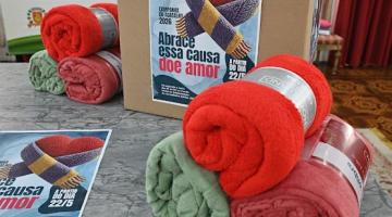 agasalhos diante de caixa de campanha. #paratodosverem