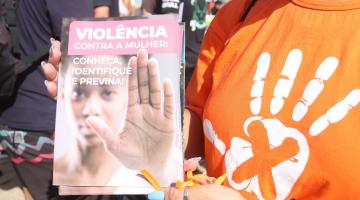 pessoa mostra panfleto de violência contra a mulher #paratodosverem 