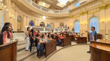 alunos sentados na sala princesa isabel ouvindo guia #paratodosverem