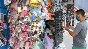 banca de comércio ambulante cheia de produtos pendurados, como óculos, capas de celular, brinquedos et