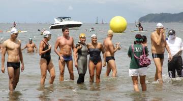 A campeã olímpica tira fotos com participantes da prova já na saída da água. #pracegover