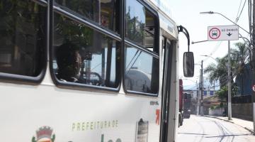 ônibus passa em faixa com placa em cima #paratodosverem 