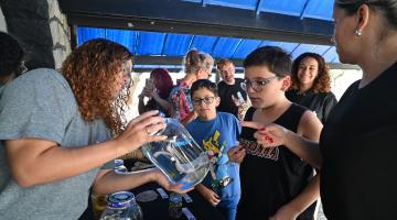 monitora mostra vidro com animal para aluno #paratodosverem 