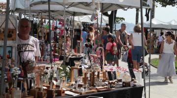 pessoas olham produtos em feira #paratodosverem 