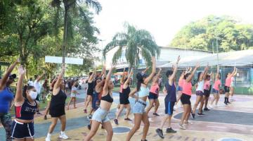 mulheres fazem movimentos iguais de dança em praça. #pratodosverem