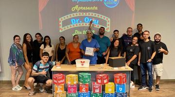 atores e alunos posam na frente de mesa com cubos indicando os objetivos do desenvolvimento sustentável #paratodosverem 