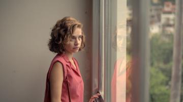 mulher olha janela em cena do filme #paratodosverem