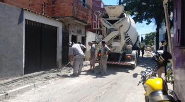 Caminhão está parado em via fazendo a concretagem de calçada do lado esquerdo