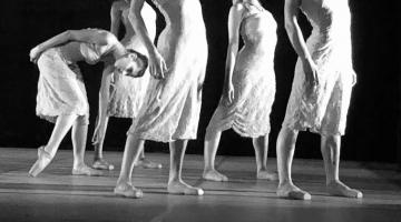 foto em preto e branco. Cinco bailarinas estão em pé em coreografia. Quatro deles estão com o tronco alongado para trás. Uma delas se curva para a frente. #paratodosverem