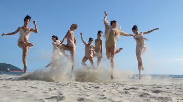 Bailarinas dançando na faixa de areia da praia #paratodosverem
