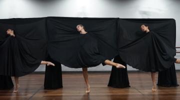 Bailarinas dançam cobertas por pano preto #paratodosverem