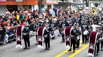 banda está desfilando em avenida. #paratodosverem