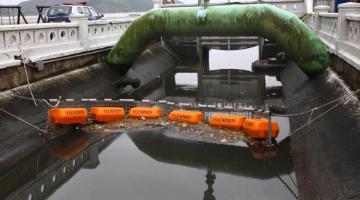 barreira flutuante em canal retém detritos que poderiam ir para o mar. #paratodosverem 