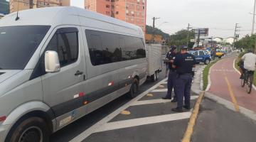 Van estacionada com guardas municipais ao lado. #pracegover