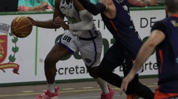 Jogadores de basquete disputando partida. #Paratodosverem.