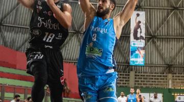 dois jogadores estão em quadra. O da direita é da equipe santista e o da esquerda, com a bola na mão é de uma equipe adversária. #paratodosverem