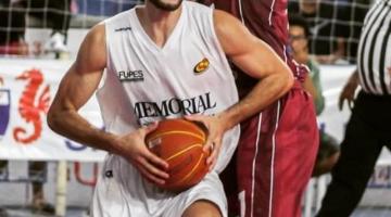 Jogador de basquete segurando a bola na partida e sendo marcado #paratodosverem