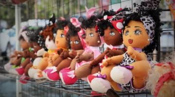 Bonecas de mulheres afros penduradas em uma parede. #paratodosverem
