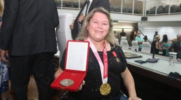 Atleta exibe medalha com medalha paralimpica no peito #paratodosverem