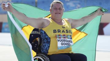 atleta na cadeira de rodas segurando a bandeira do brasil #paratodosverem