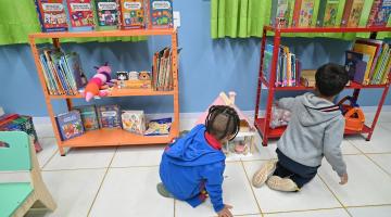 crianças olham livros #paratodosverem