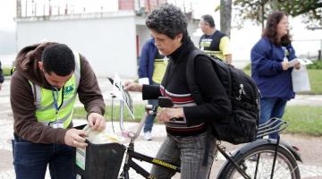 Agente prende na cestinha de bicicleta peça sobre respeito ao ciclista. #pracegover