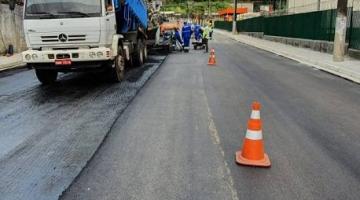 Caminhão que aplica massa asfáltica está na pista. Outro trecho está bloqueado. 