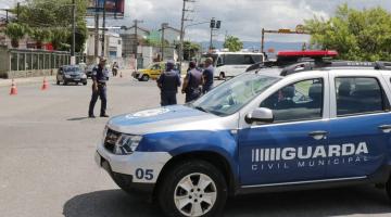 Viatura da guarda municipal está parada em via. Ao fundo, guardas e agentes da CET monitoram o trânsito