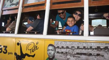 pessoas sorriem na janela do bonde #paratodosverem