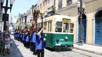 Bonde é recepcionado com apresentação de boneco de dragão. #pracegover