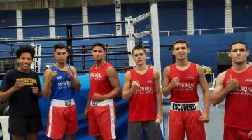 equipe de boxe posa para foto com ringue ao fundo #paratodosverem