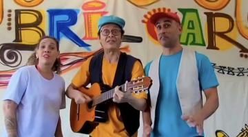 três atores do espetáculo, com um deles ao centro com um violão #paratodosverem