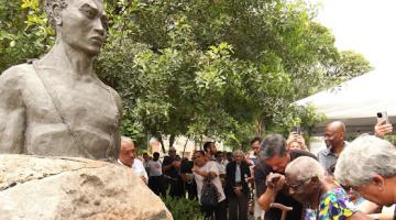 pessoas depositam flores no busto #paratodosverem