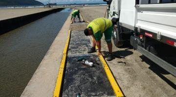 dois homens estão trabalhando na beira do canal 3 para trocar peças da passarela. #paratodosverem 