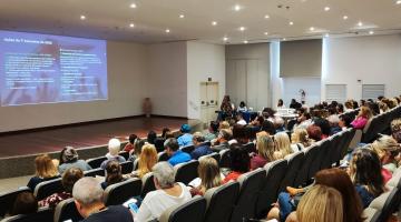 servidores sentados em auditório assistindo palestra. #paratodosverem