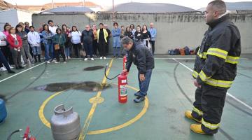 bombeiro observa pessoa utilizando extintor durante capacitação #paratodosverem
