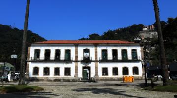 a fachada da cadeia velha, com palmeiras nas duas laterais e em primeiro plano, como se estivessem emoldurando o grande patrimônio. #paratodosverem