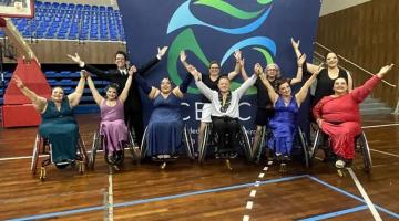 equipe de dançarinos em cadeira de rodas posa para fotos com os braços para o alto. #paratodosverem 