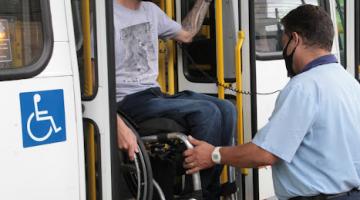 Cadeirante no alto de elevador operado por motorista de ônibus. #pratodosverem