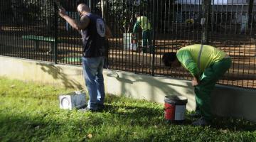 homem pintam mureta na praça. #paratodosverem