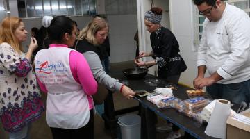 Público é servido pelo chef de cozinha e uma cozinheira. #Pracegover