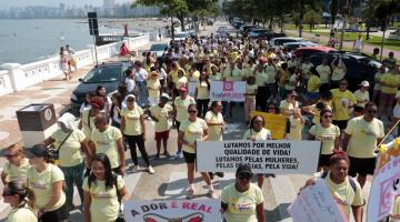 pessoas caminhando de amarelo na avenida da praia #paratodosverem 
