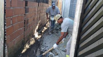 dois homens trabalham na demolição de calçada. #paratodosverem