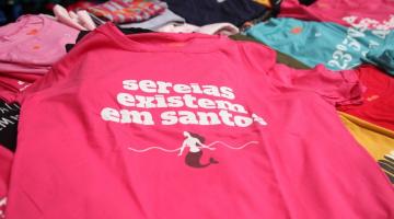 camiseta onde se lê Sereias existem em Santos. Arte é de uma sereia no mar. #paratodosverem