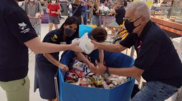 Pessoas mexem em caixa com alimentos no supermercado #paratodosverem