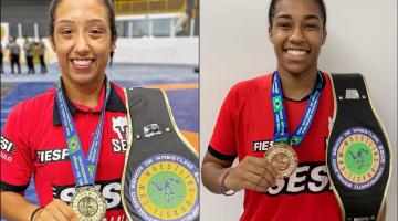 Thalia Freitas e Mayara Ramos seguram medalhas e cinturões sorrindo para a foto. #paratodosverem