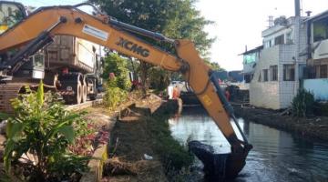 braço mecânico de caminhão estã removendo lama de canal. #paratodosverem